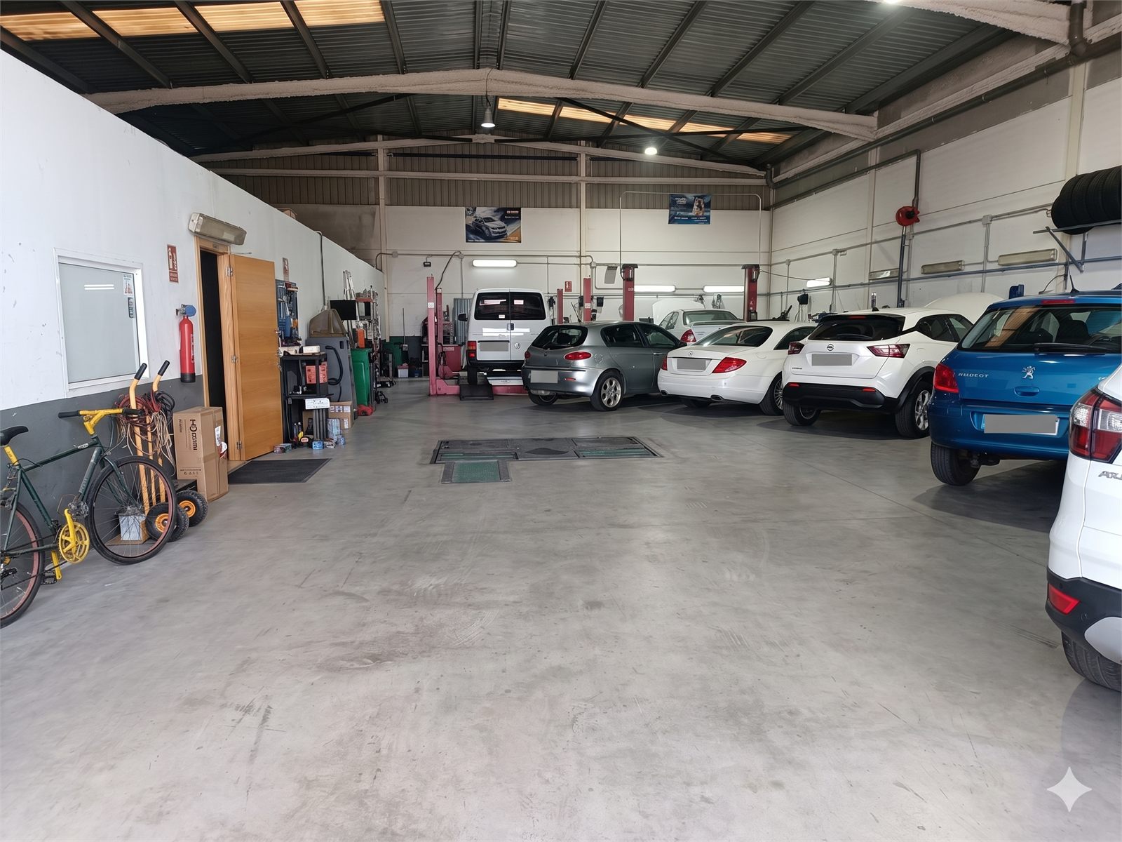 Interior del taller con vehiculos y puestos de trabajo